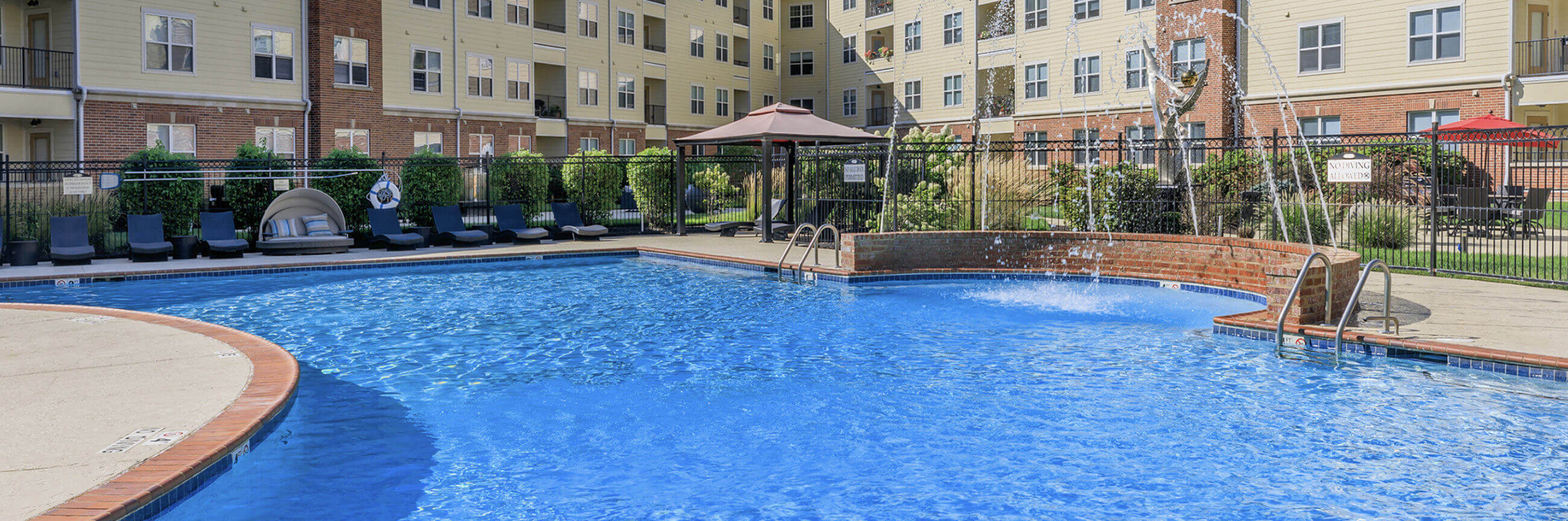 Apartment pool with lounge chairs