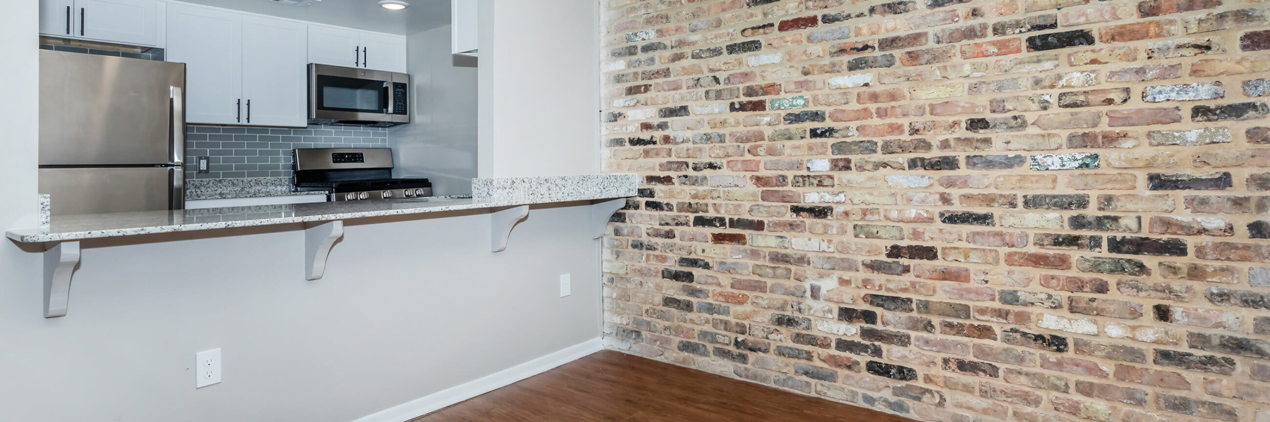 Apartment kitchen with marble counters and white accents