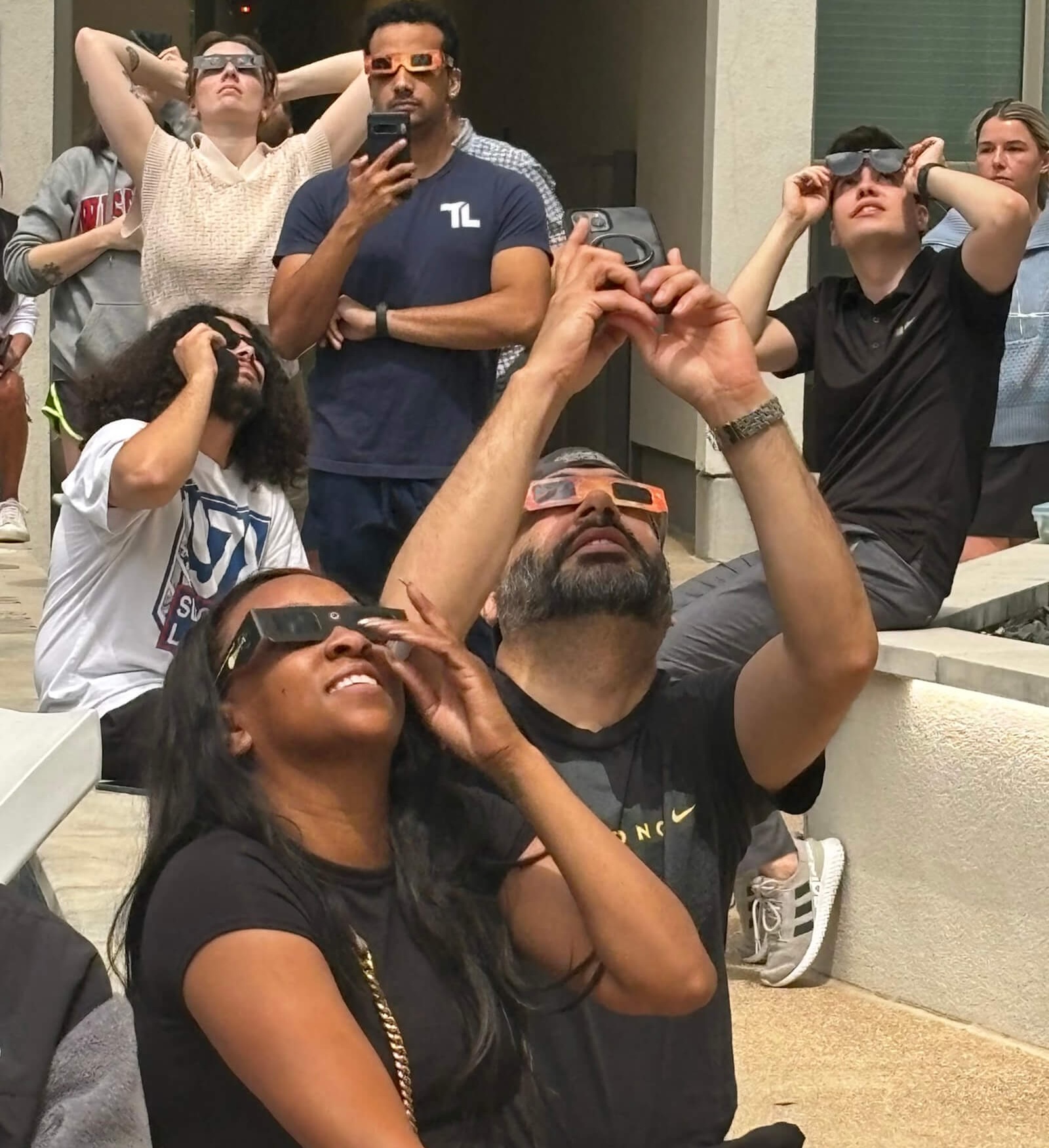 Group of people looking up wearing solar eclipse glasses