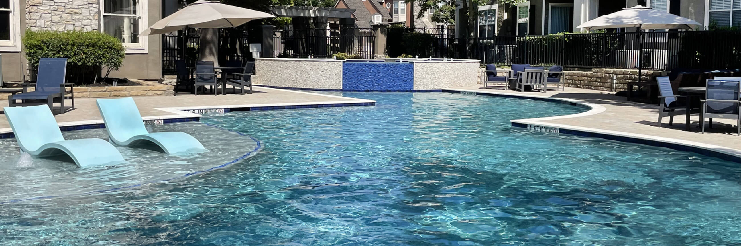 Apartment pool with lounge chairs