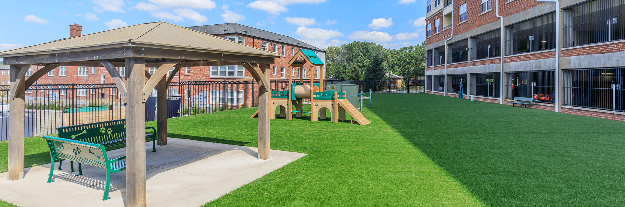 Exterior of an apartment building with dog park and tables