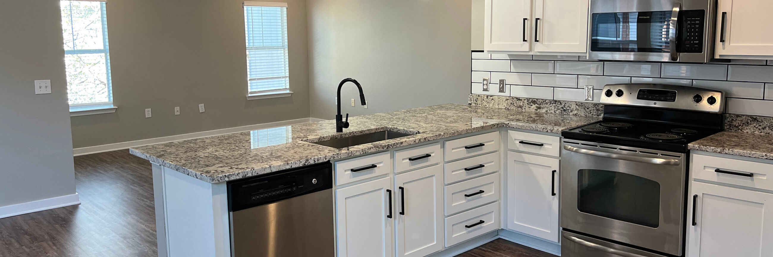 Apartment kitchen with marble counters and white accents